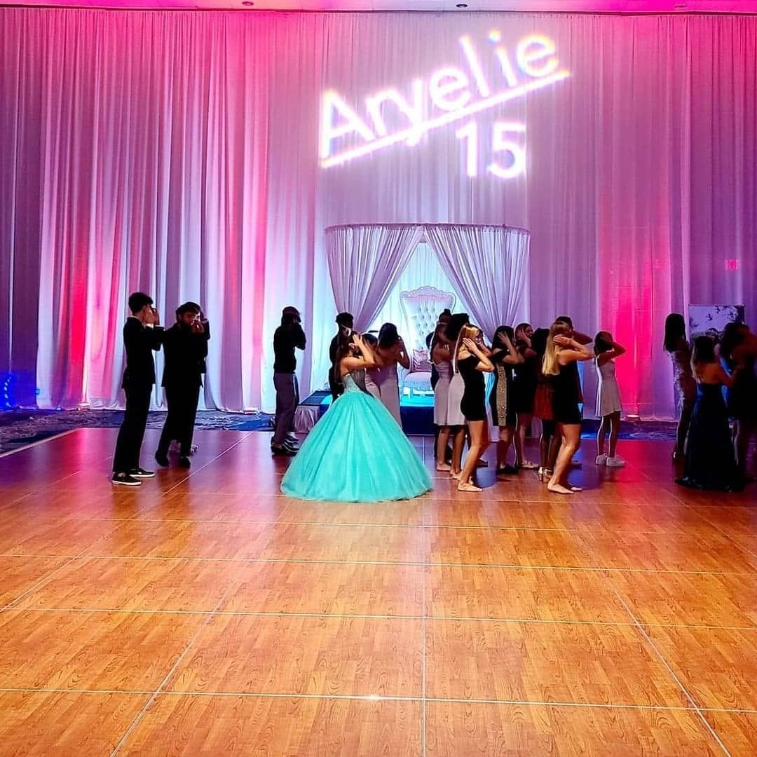 Quinceañera celebration with pipe and drape backdrop and projection lighting